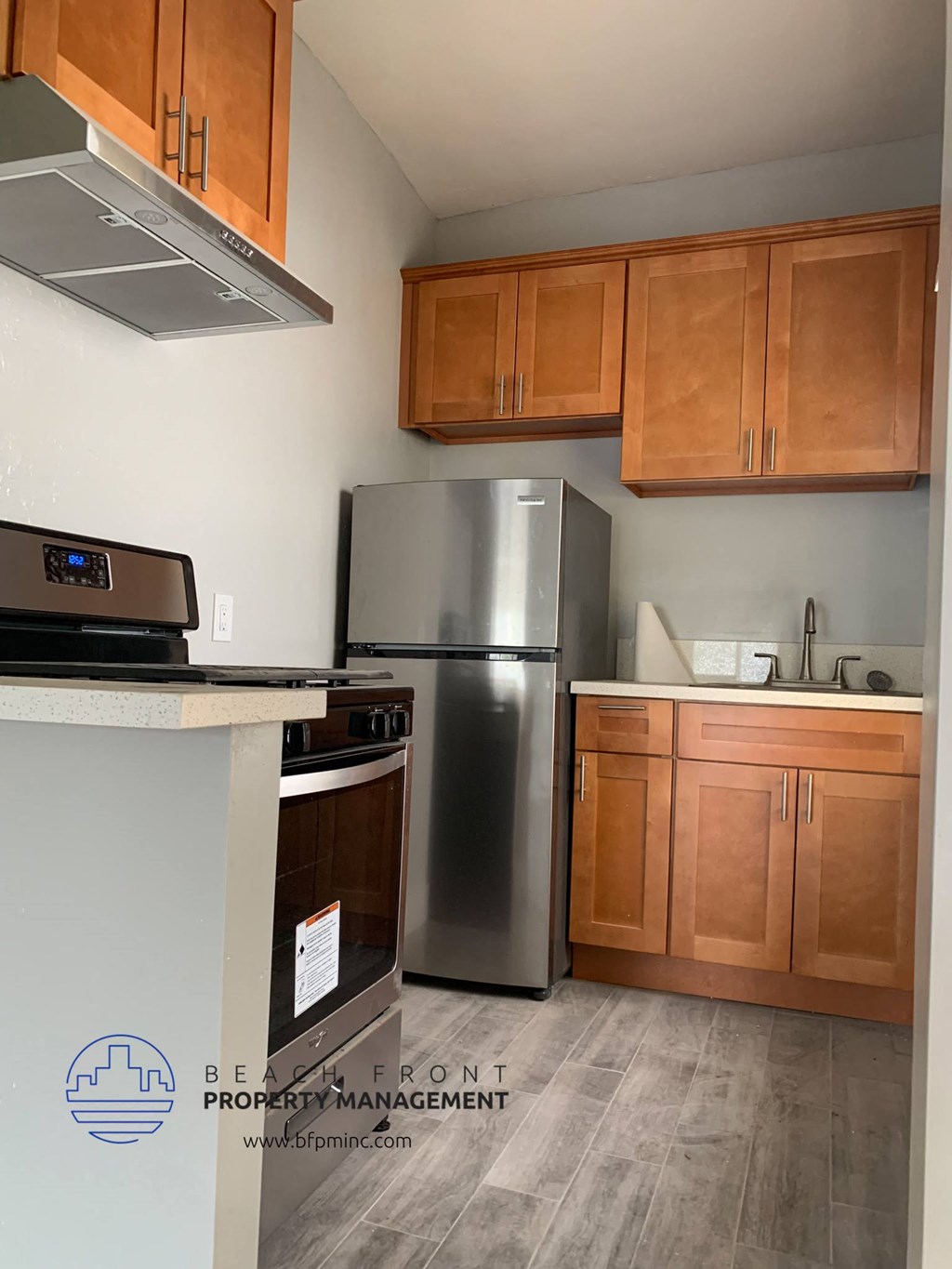 a kitchen with wooden cabinets and a stainless steel refrigerator