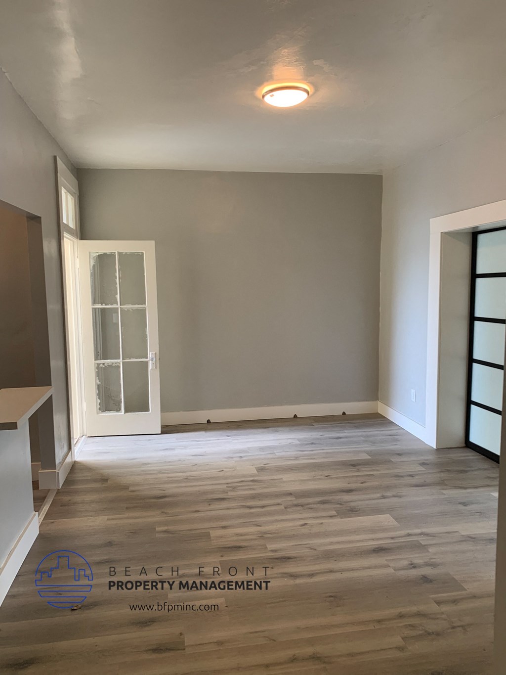 an empty living room with grey walls and a white door