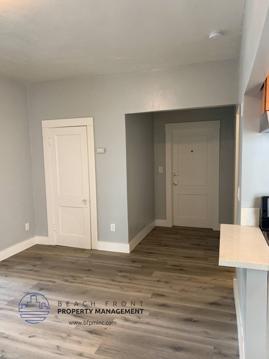 a living room with grey walls and white doors    and a white door