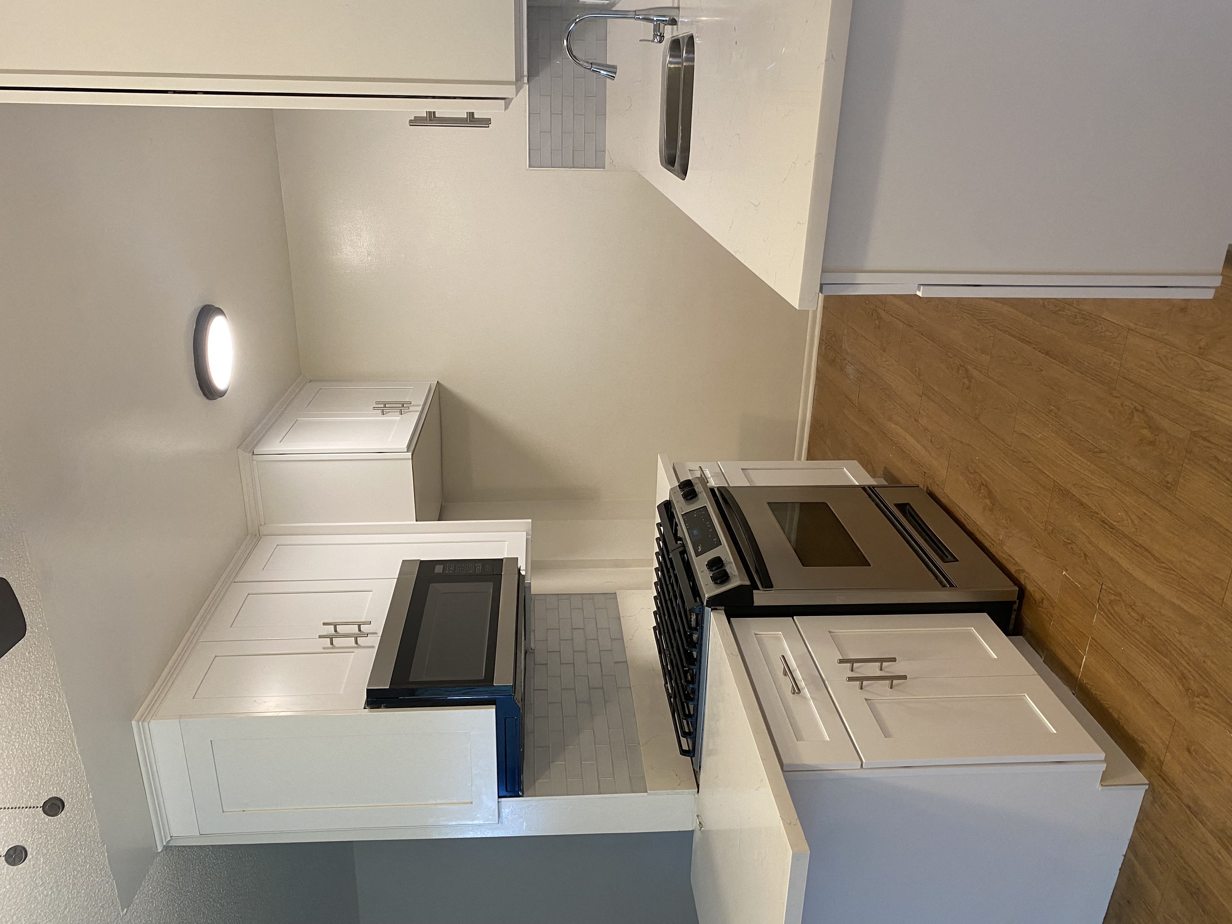 an overhead view of a kitchen with white cabinets and stainless steel appliances