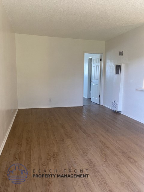 the living room of an empty apartment with wood flooring