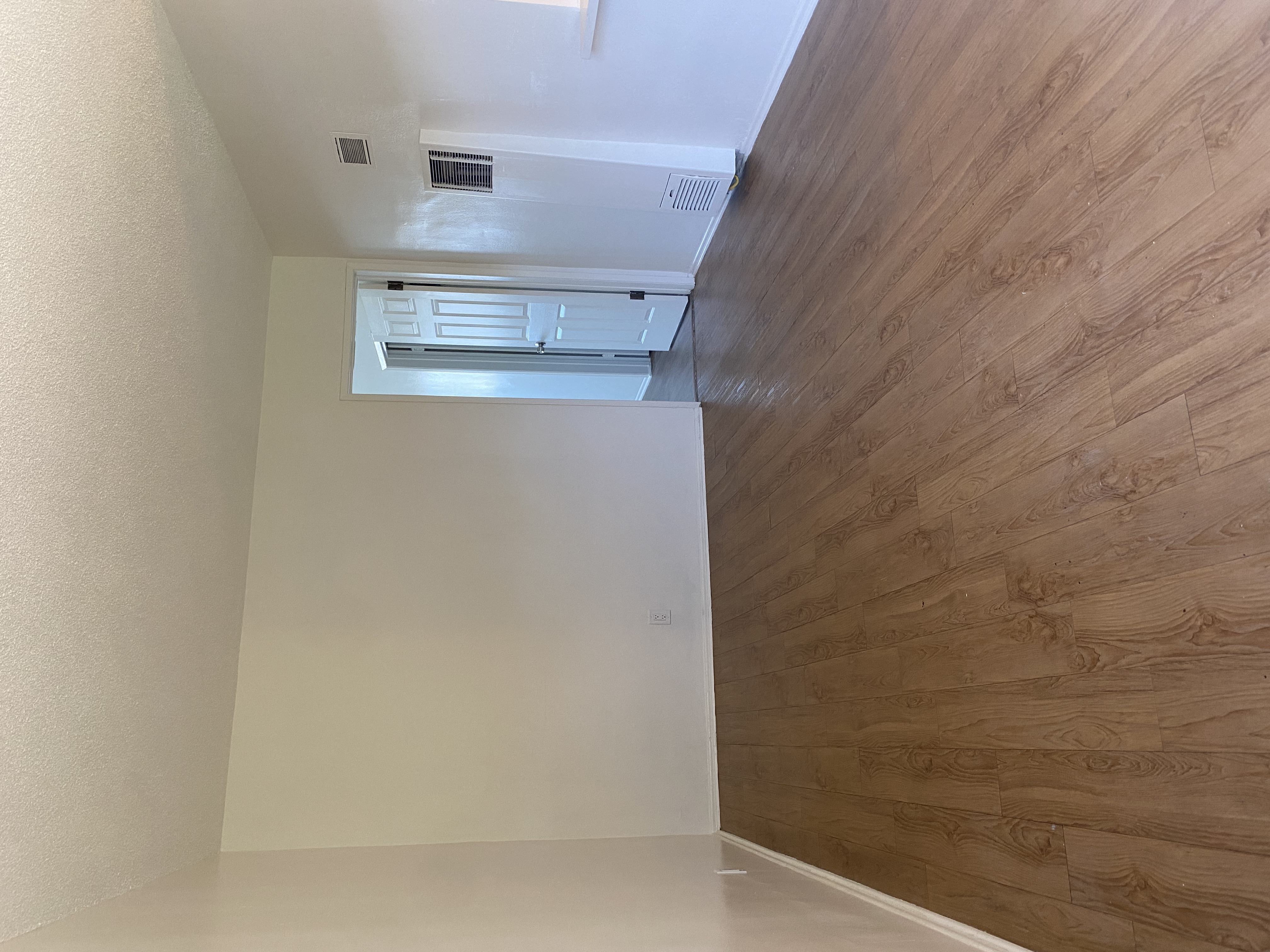a room with a wooden wall and an air conditioning unit on the ceiling