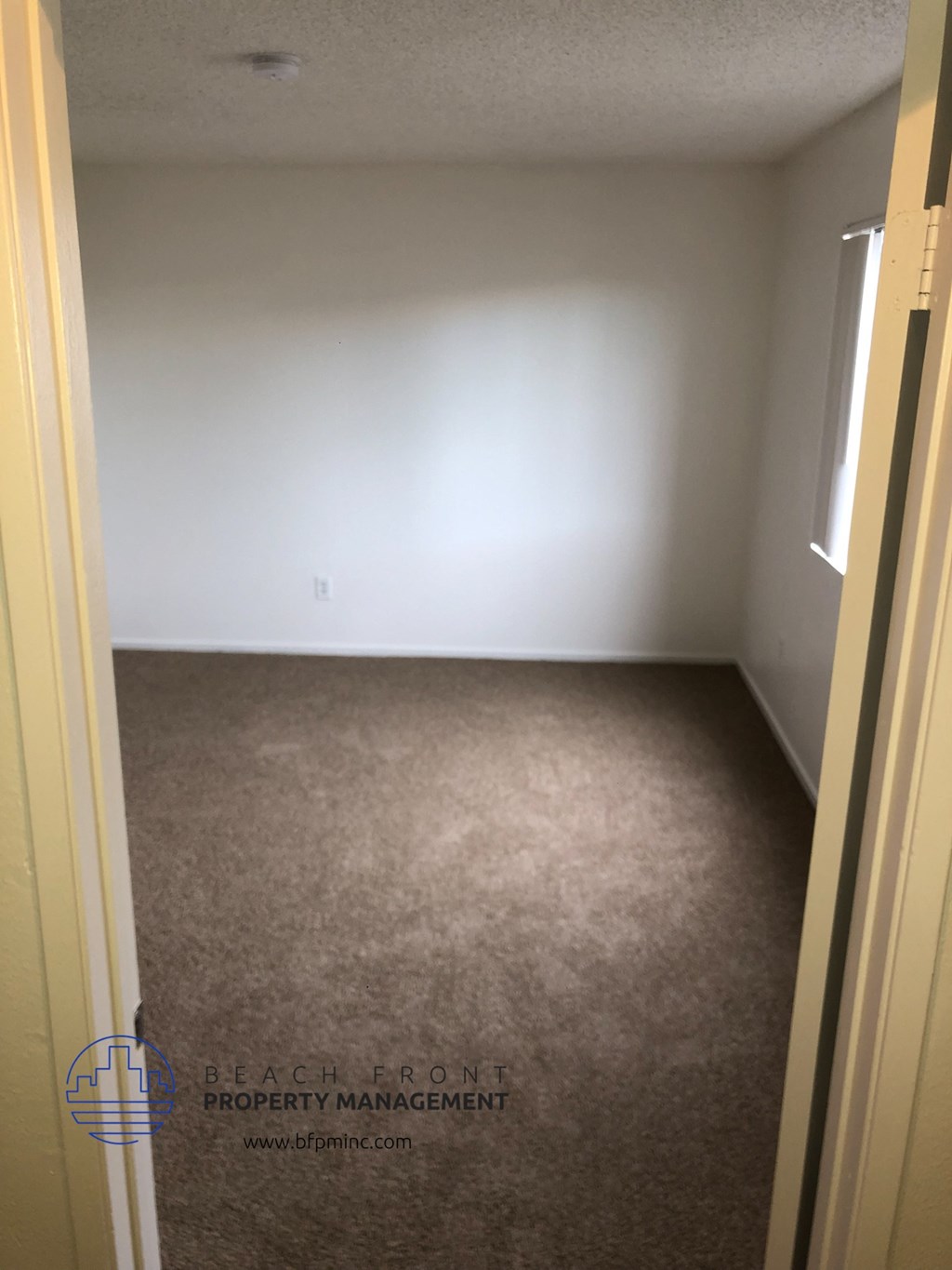 a room with a carpeted floor and a white wall