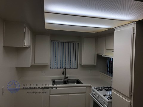 a kitchen with white cabinets and a sink