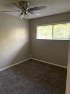 an empty room with a ceiling fan and a window