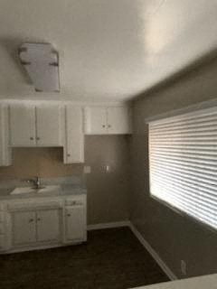 a kitchen with white cabinets and a sink and a window