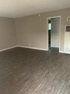 an empty living room with a wood floor