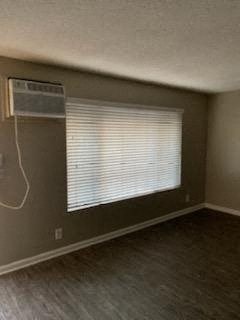 an empty living room with a window and wood floors