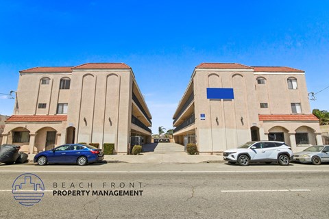 Two buildings with cars parked in front and a sign that says "Beach Front Property Management".