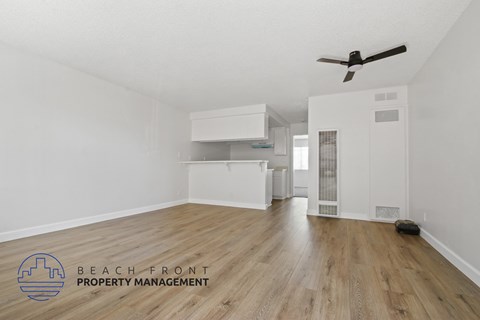 A room with a ceiling fan and wooden flooring.