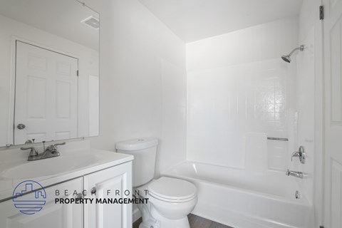 A white bathroom with a toilet, sink, and bathtub.