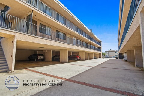 A parking garage with a clear blue sky in the background and a logo for Beach Front Property Management.