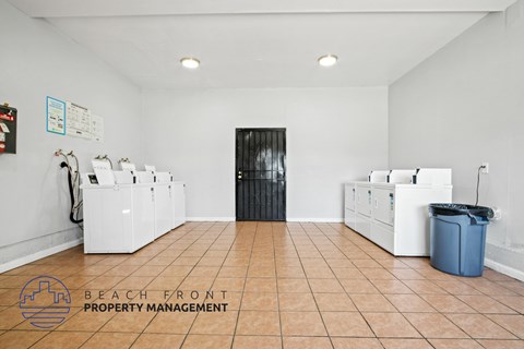 A clean, empty room with a sign that says "Beach Front Property Management".