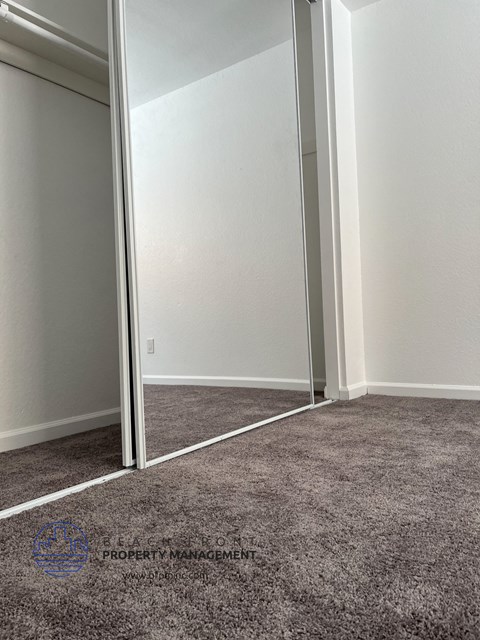 a carpeted room with a door to a closet