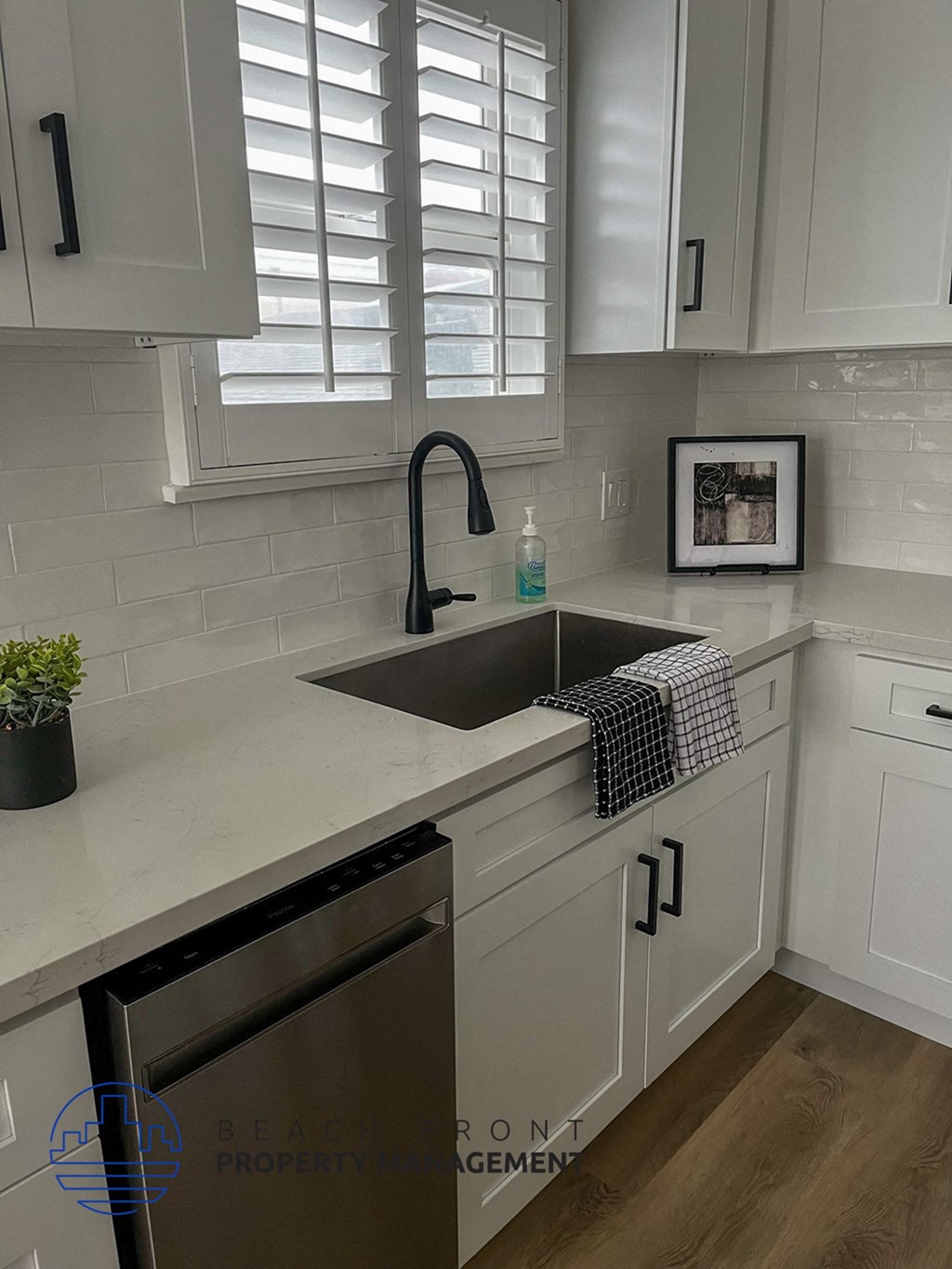 a white kitchen with a sink and white cabinets