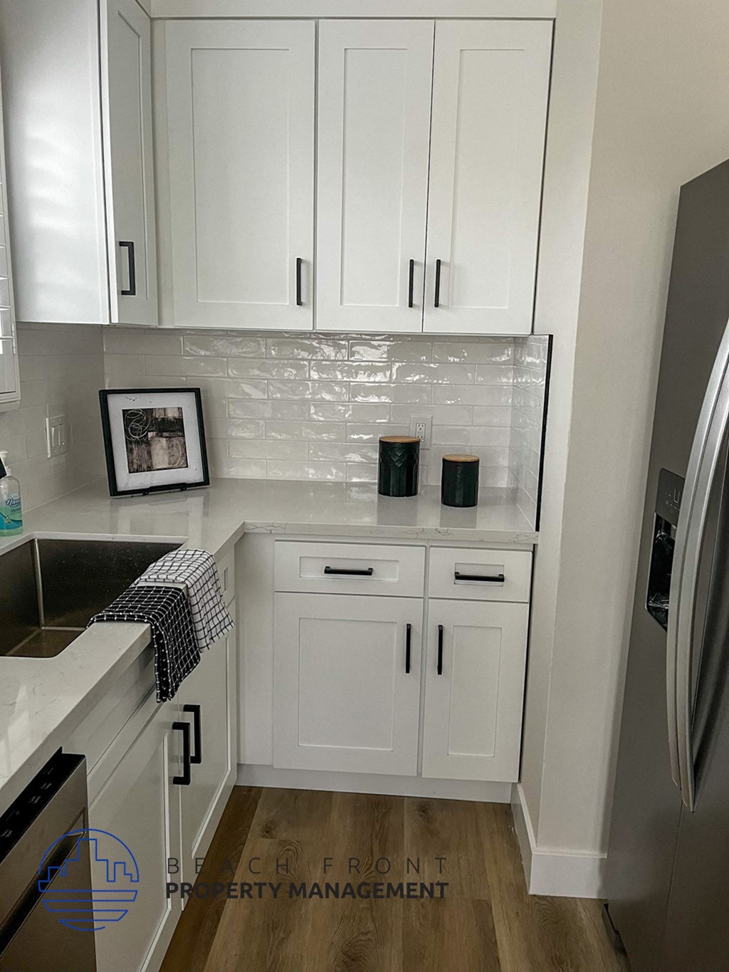 a small white kitchen with white cabinets and a sink
