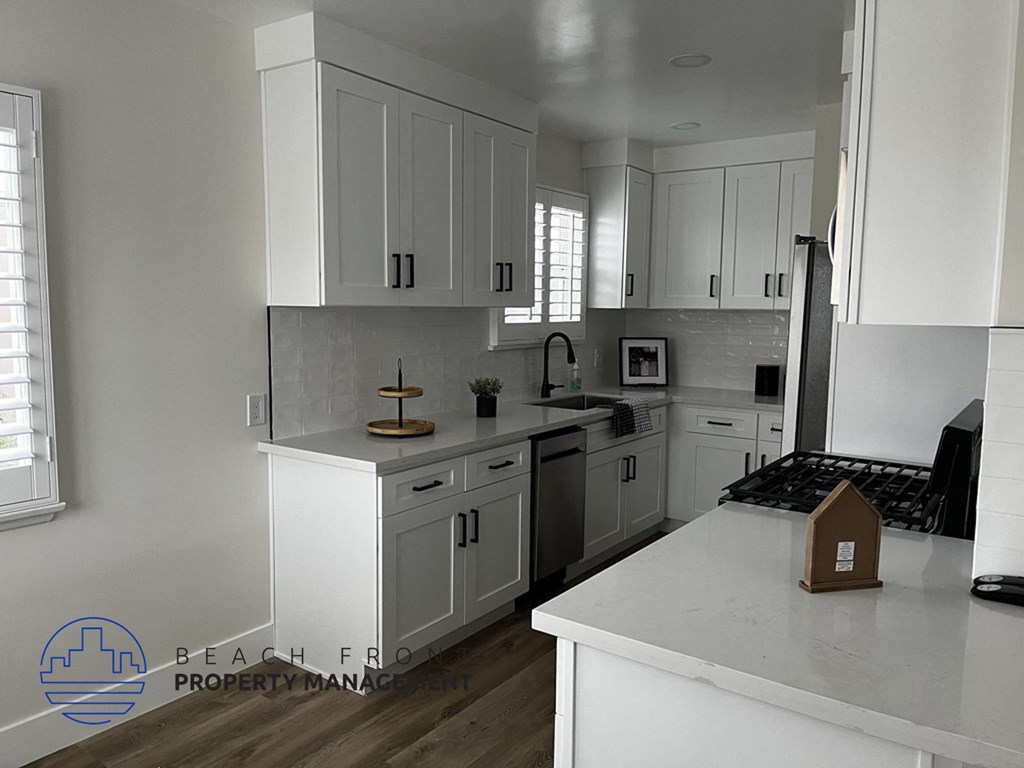 a white kitchen with white cabinets and white counter tops