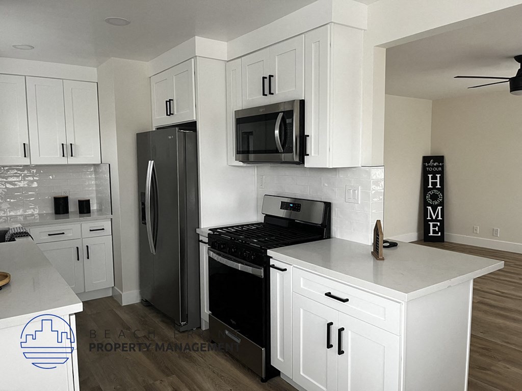 a white kitchen with stainless steel appliances and white cabinets
