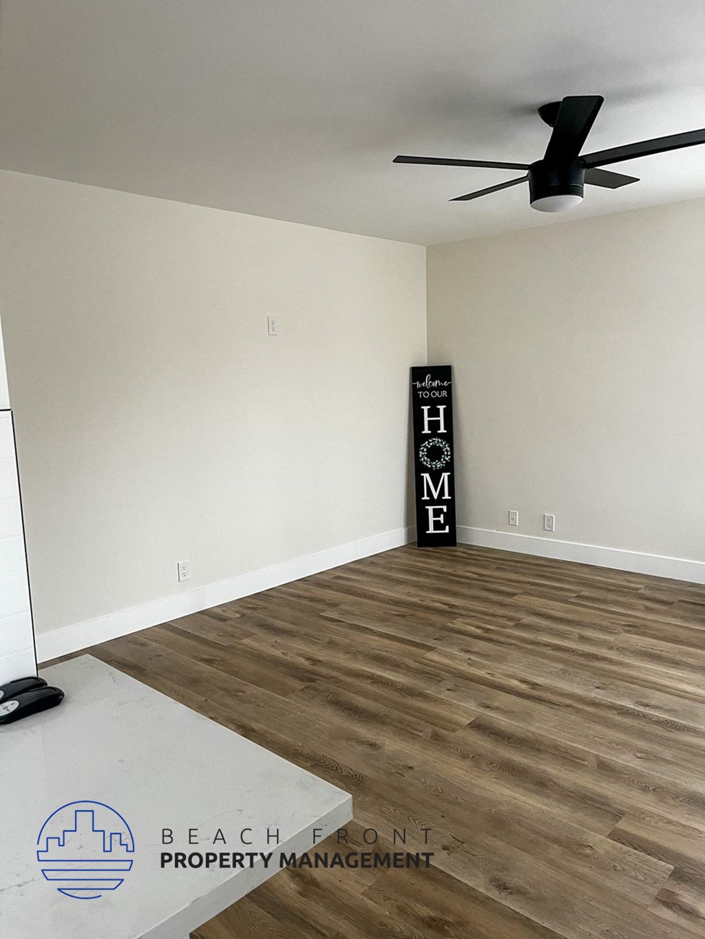 A room with a wooden floor and a sign that says "HOME".