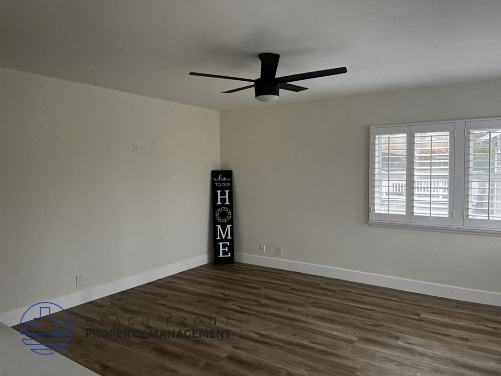 a living room with wood floors and a ceiling fan