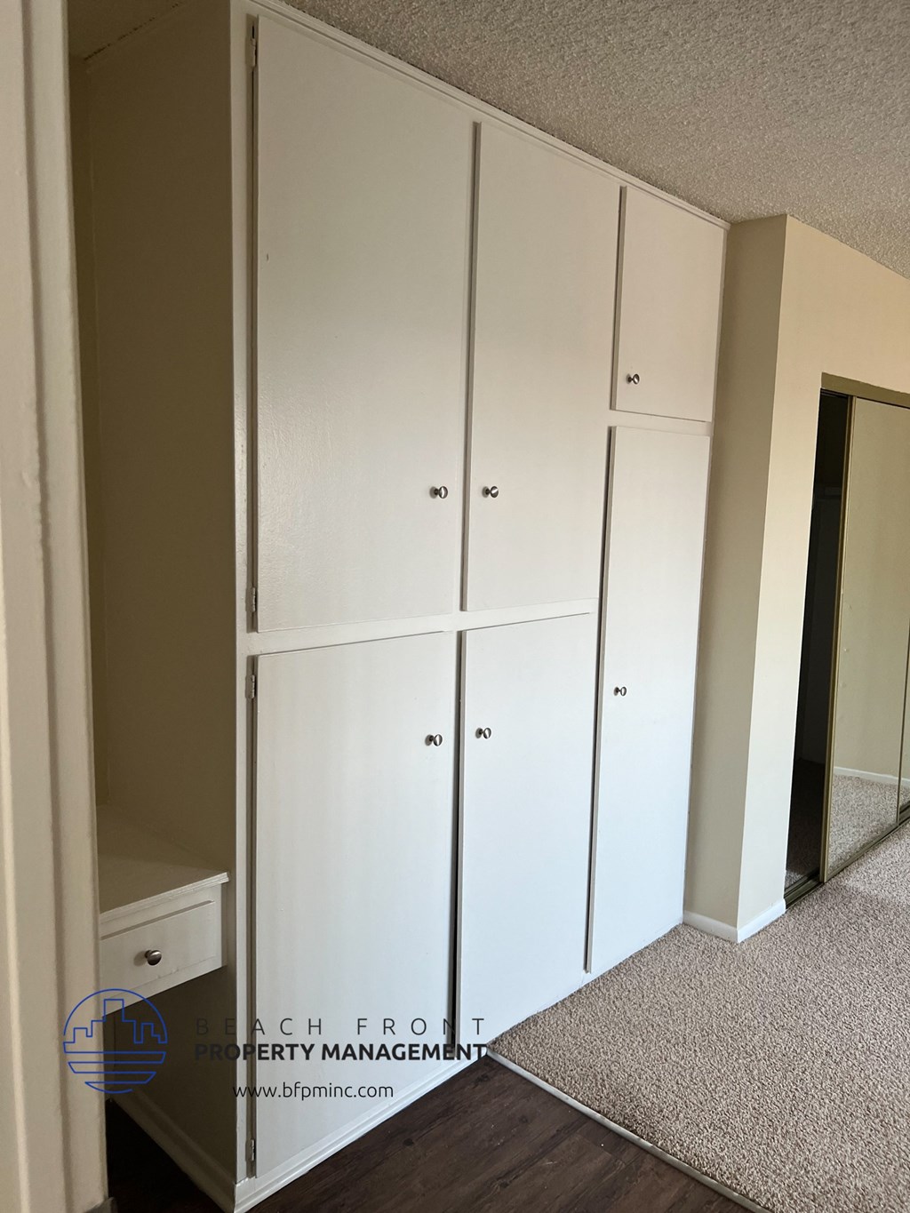 a row of white closets in a room with a carpet