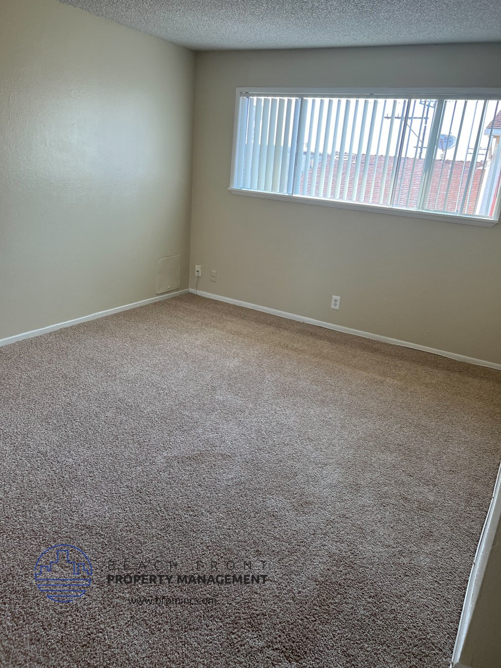 an empty room with carpet and a window