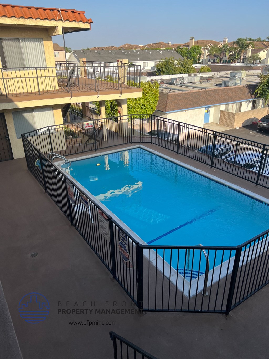 a view of the pool at the top of a building with a fence around it