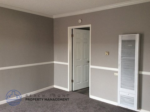 a bedroom with a white door and grey walls and a white closet
