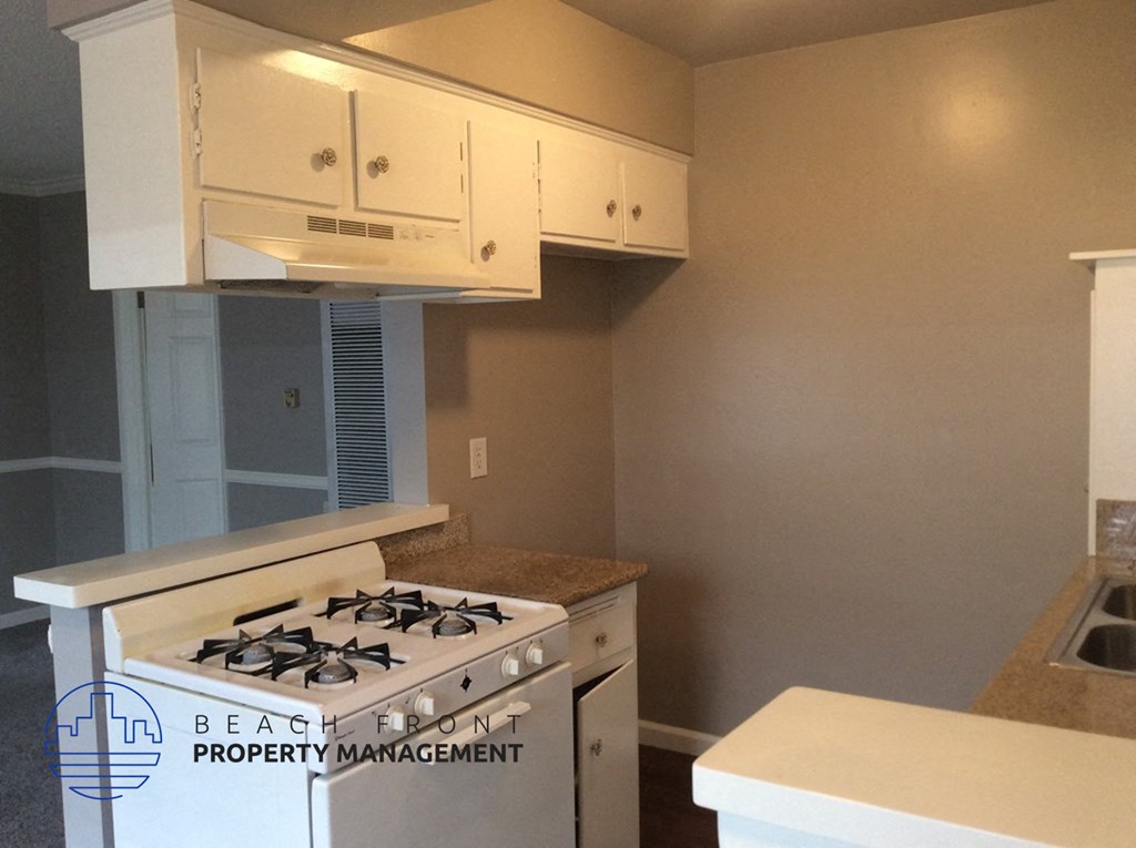 a kitchen with a stove and white cabinets