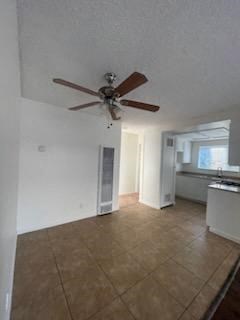 an empty living room with a ceiling fan