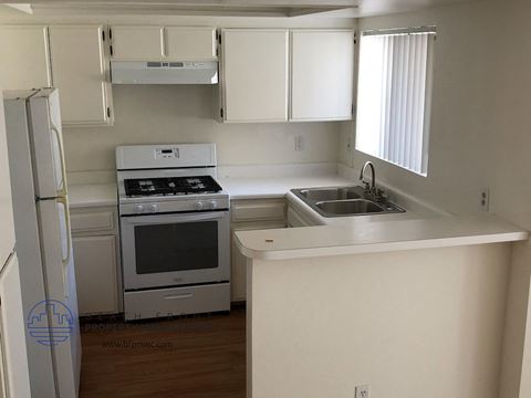 a small kitchen with white cabinets and white appliances