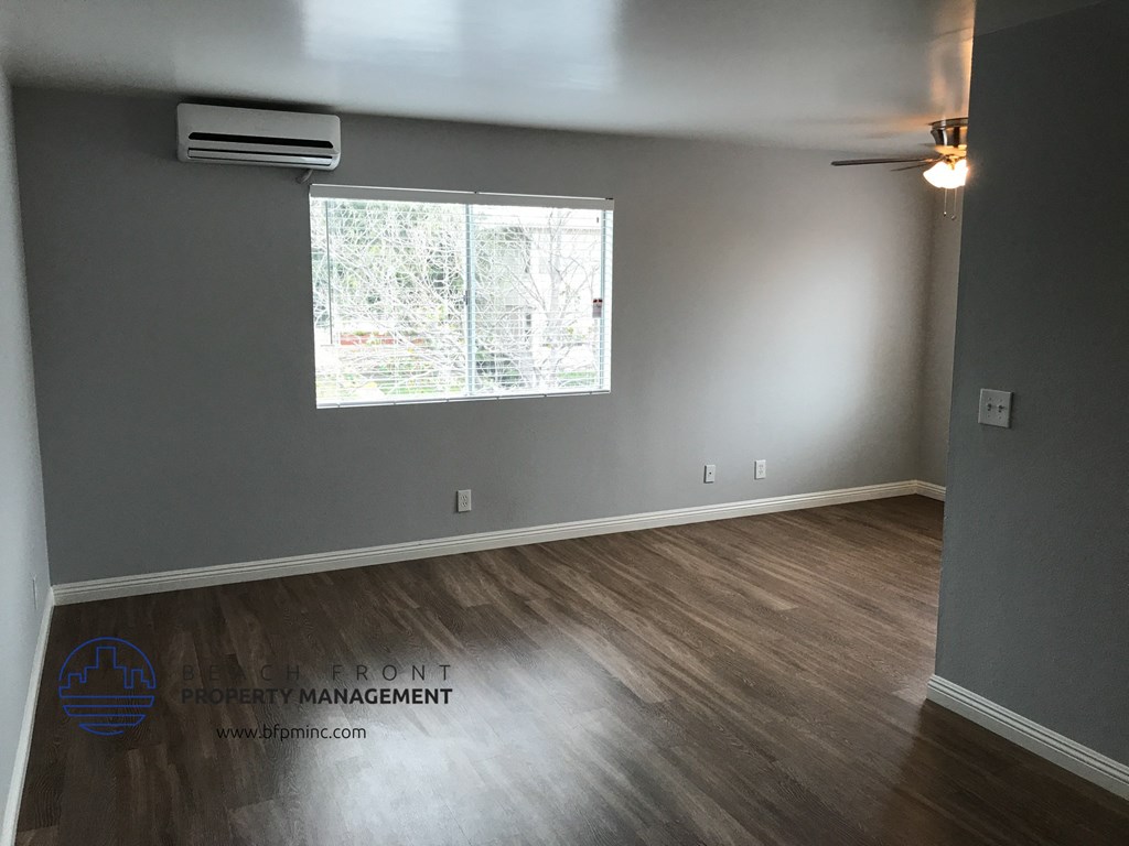 the living room of a house with gray walls and a window