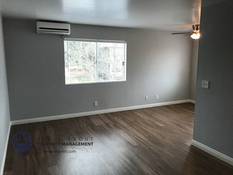 the living room of a house with gray walls and a window