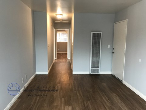 a renovated living room and hallway with wood floors and blue walls