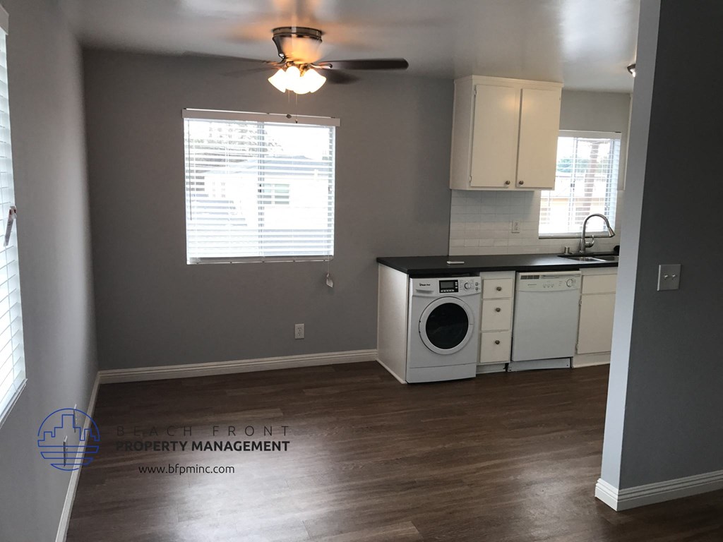 a kitchen with a washer and dryer and a ceiling fan