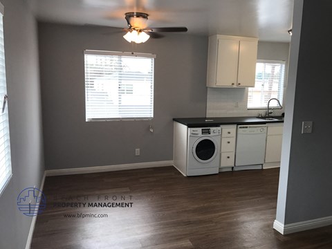 a kitchen with a washer and dryer and a ceiling fan