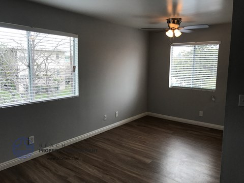 a bedroom with a large window and a ceiling fan