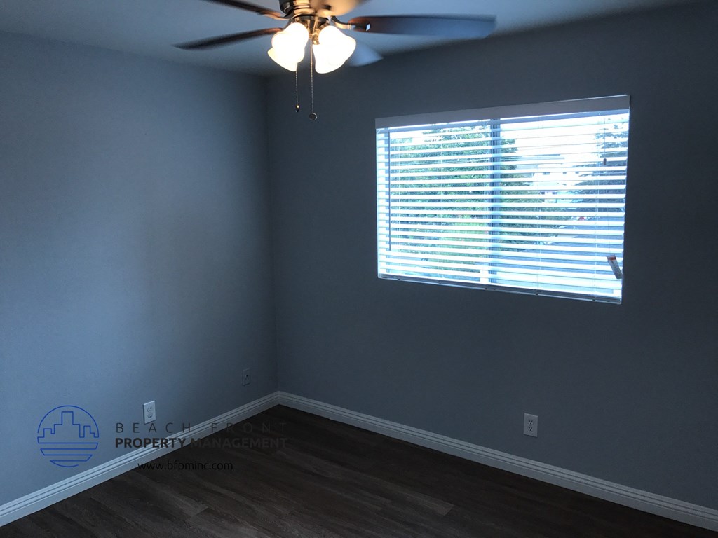 a bedroom with a ceiling fan and a window