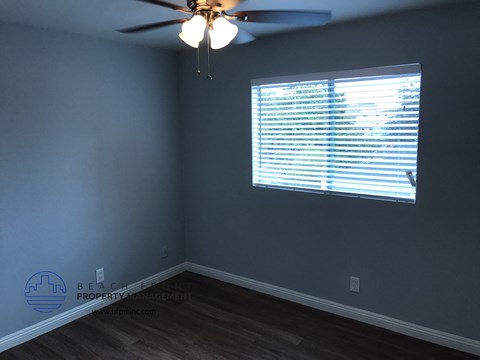 a bedroom with a ceiling fan and a window