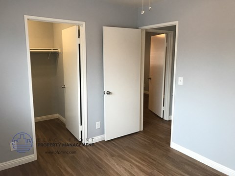 an empty room with three doors and a closet