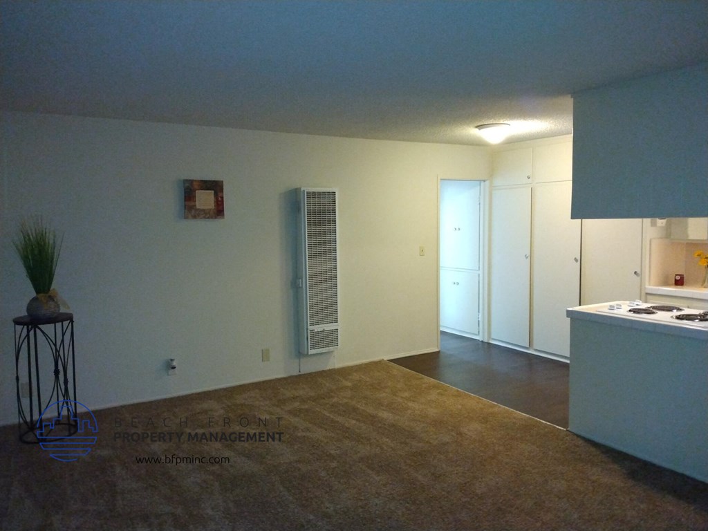 an empty living room and kitchen with an air conditioner