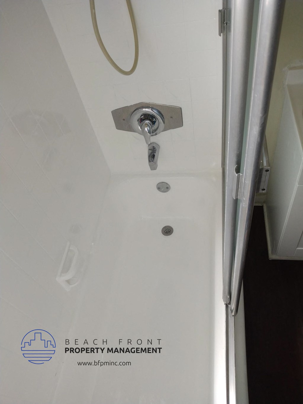 a shower in a small bathroom with the door open