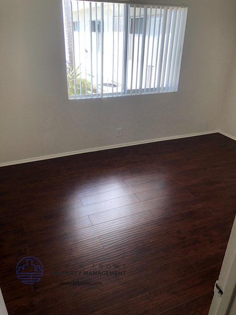 an empty room with wooden floors and a window