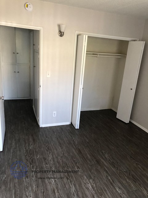 an empty living room with wood floors and a closet