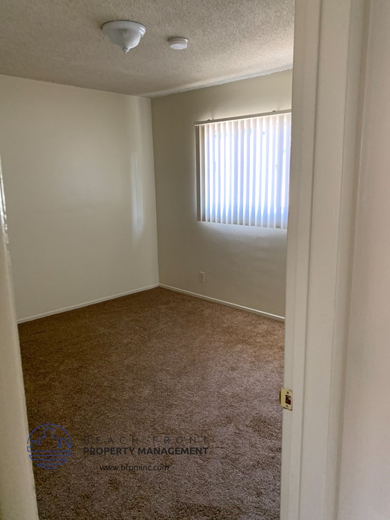 an empty room with a window and a carpet