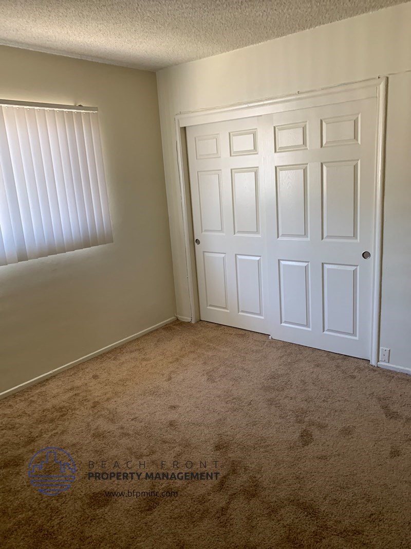 a bedroom with a closet and a door and a window