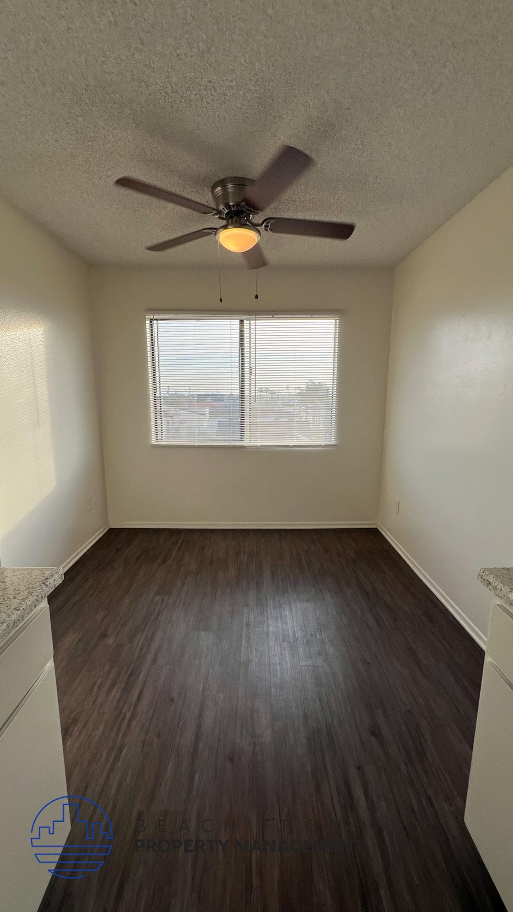 A room with a ceiling fan and a window.