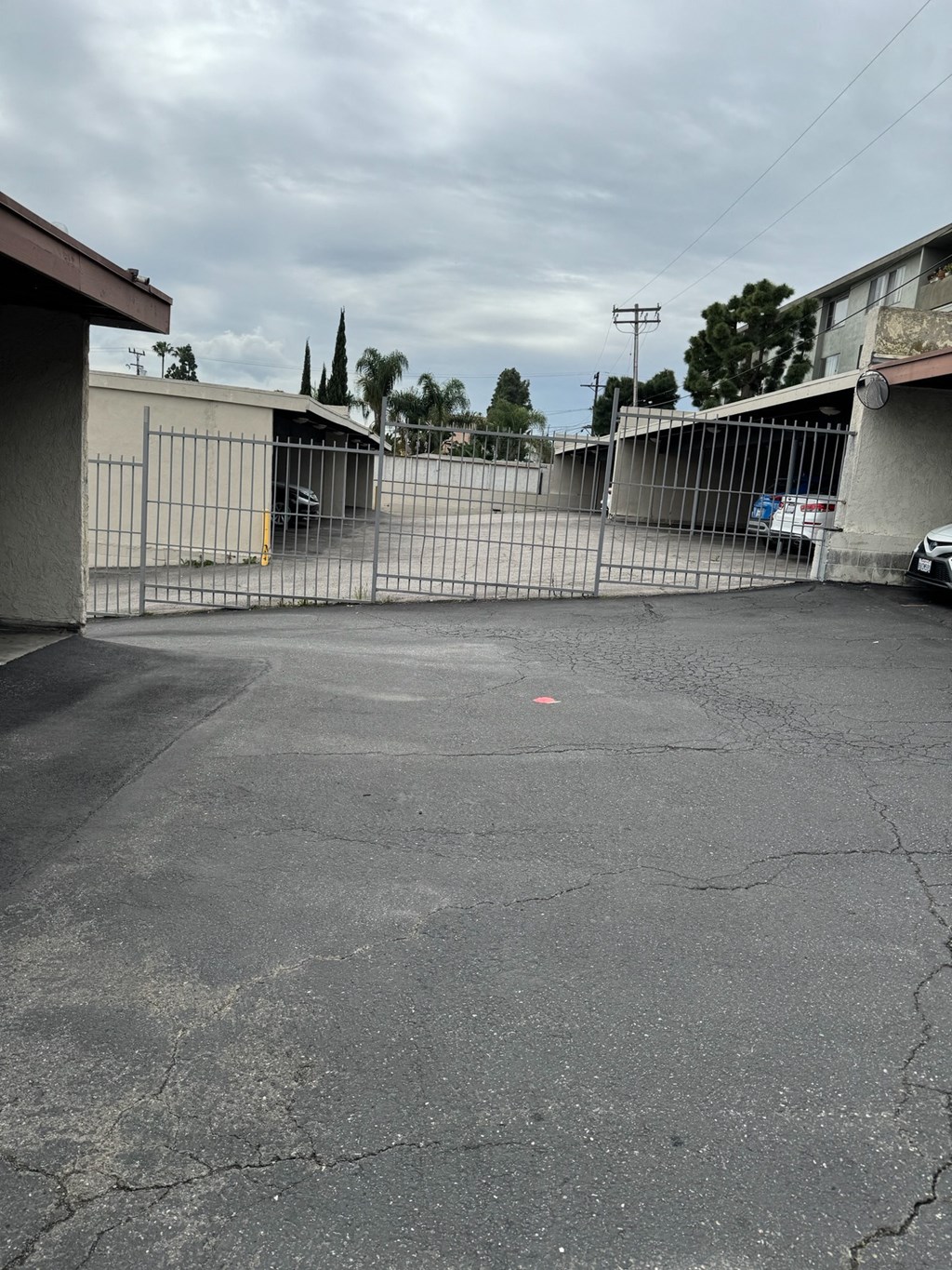 an empty parking lot in front of a white gate