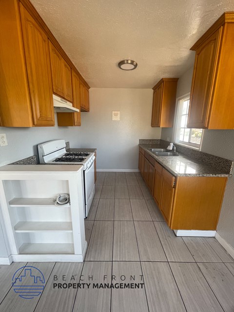 a kitchen with wooden cabinets and a stove and a sink