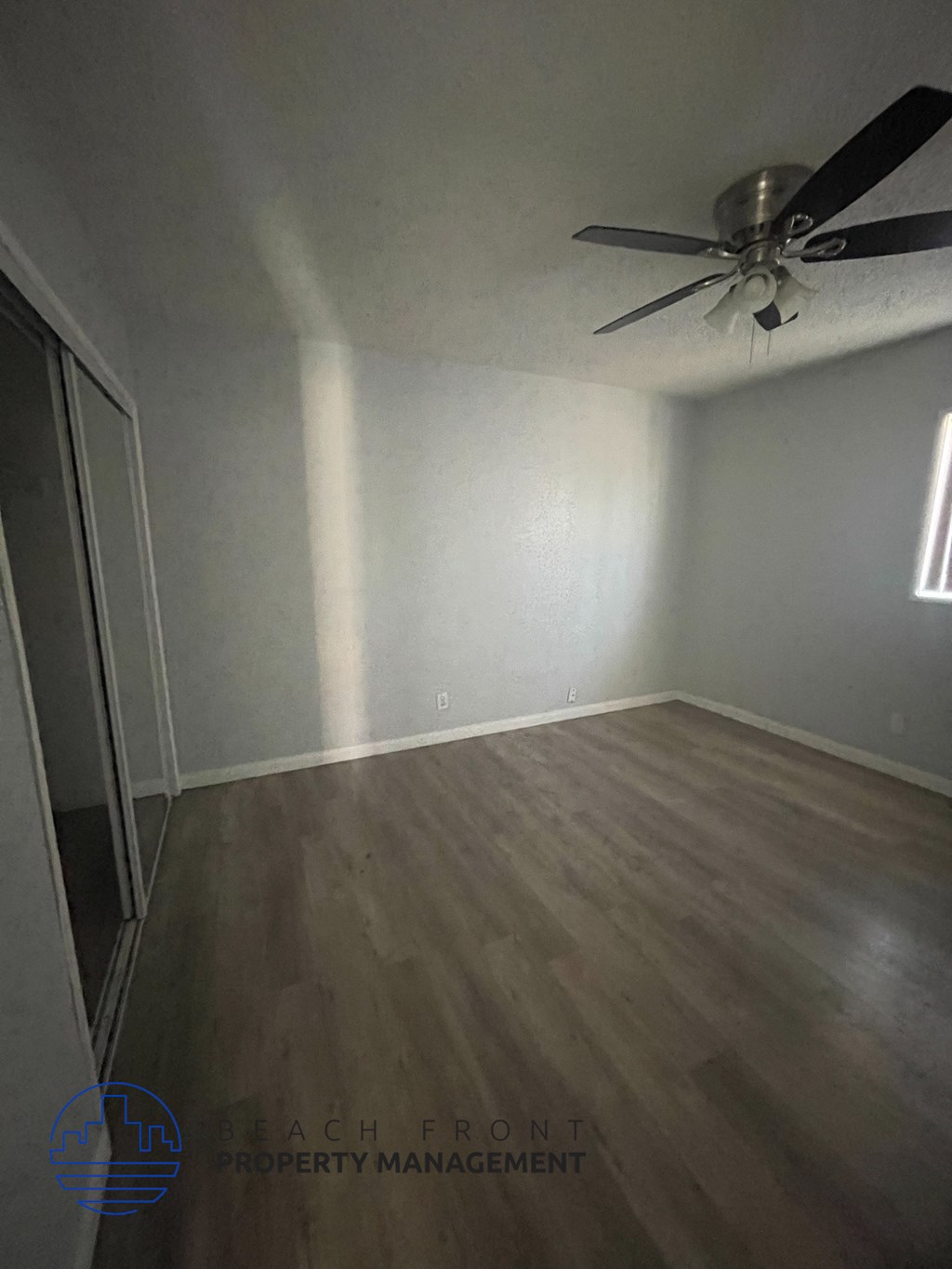 a room with wood floors and a ceiling fan